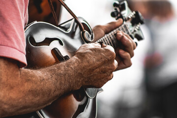 mature adult man playing a mandolin outside