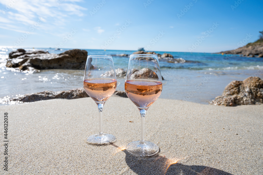 Summer time in Provence, two glasses of cold rose wine on sandy beach near Saint-Tropez, Var department, France - obrazy, fototapety, plakaty 