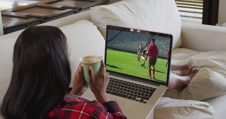 Poster - Composite of woman sitting at home holding coffee watching rugby match on laptop