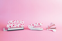 Puncher, Stapler And Staple Remover, With Pink Dots On A Pink Background. Office And School Supplies Concept. Copy-space