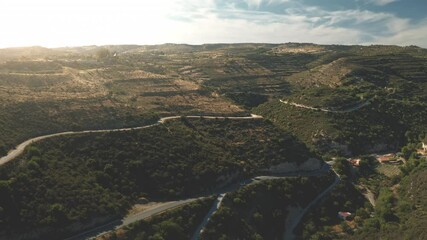 Wall Mural - Aerial roads on mountain ridge, green forest. Wilderness on hillside with nature trails. Stony sandy hill, sun light. Traveling winding ways on stone cliffs. Beautiful wild landscape. Drone flight.