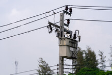 A Large Power Transformer Is Mounted On A High Voltage Pole With Wires Connected To The Transformer.