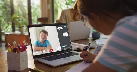 Wall Mural - Schoolgirl using laptop for online lesson at home, with school friend and web chat on screen