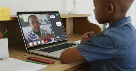 Wall Mural - Schoolboy using laptop for online lesson at home, with his colleague and web chat on screen