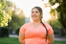 Obesity People. Plus Size Woman. Body Positive. Weight Confidence. Joyful Chubby Young Obese Overweight Girl Smiling Outdoors In Defocused Green Park Street Landscape.