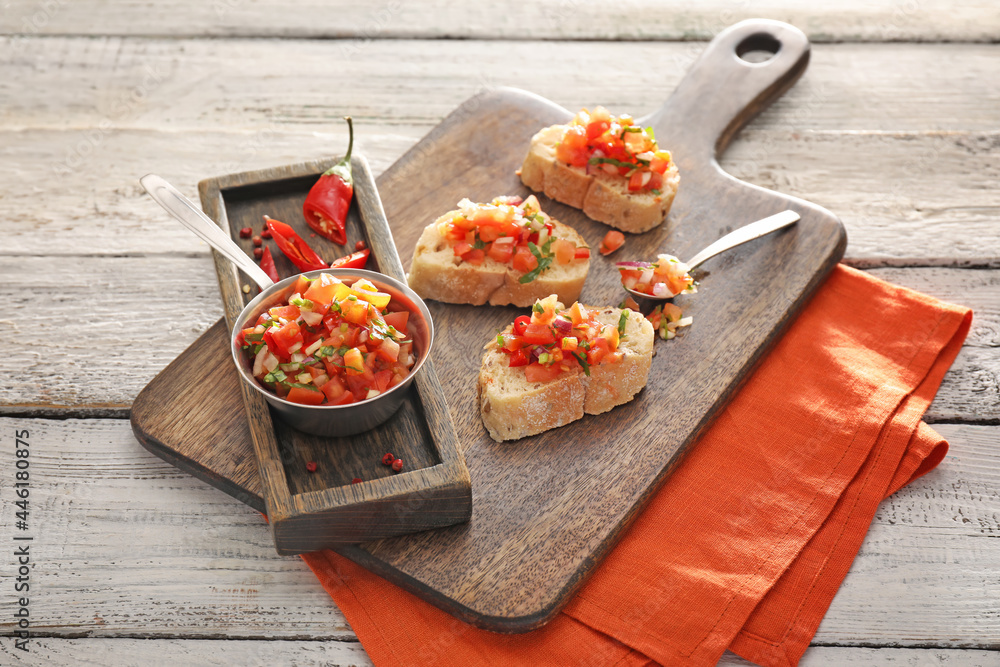 Pieces of bread with tasty salsa sauce on table