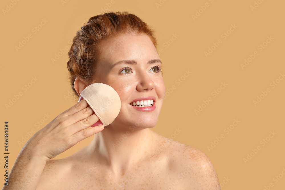 Beautiful young woman with makeup sponge on color background