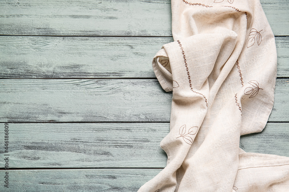 Fabric napkin on color wooden background