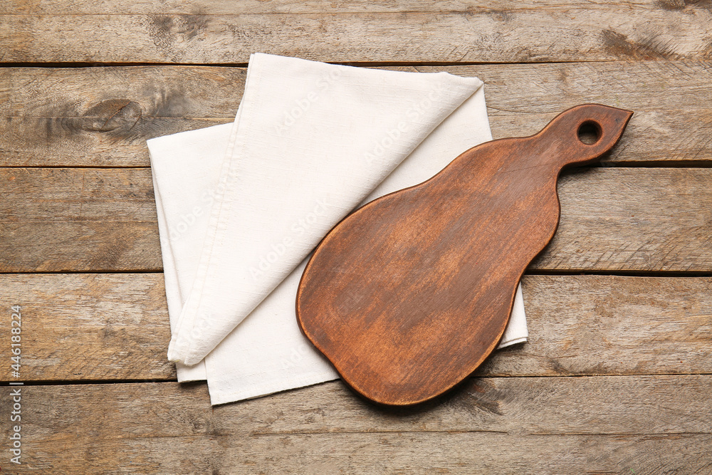 Fabric napkin and board on wooden background