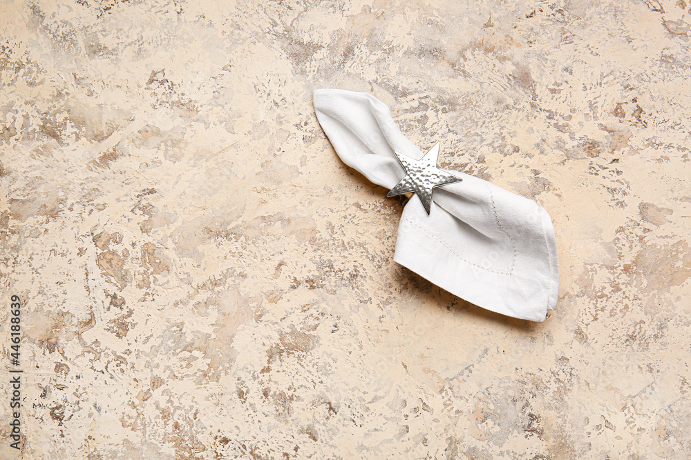 Fabric napkin with holder on grunge background