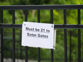 Printed sign posted on the iron gate of a bar