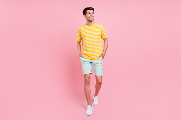 Wall Mural - Full length body size view of attractive cheerful guy walking good mood isolated over pink pastel color background