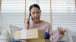 © ChayTee - Upset mad asia people young girl consumer sit sofa at home open fake product order, damage post mail buy from online shopping retail store. Shock sad teen woman unbox from wrong bad shipping service.