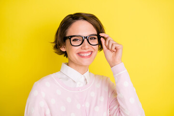 Wall Mural - Photo of young attractive woman happy positive smile hand touch glasses isolated over yellow color background