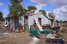 An Old Corrugated Iron Shed In Country Queensland With Accumulated Junk Scattered Around.