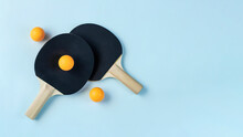 Two Black Ping Pong Paddles On Light Blue Background