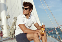 Young Man Drinking Beer On His Yacht In Sea