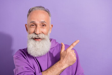 Sticker - Portrait of attractive elderly retired trendy grey-haired man showing copy space advert isolated over purple violet color background