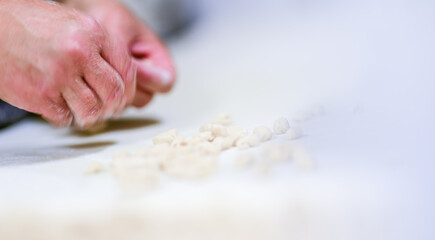 Sticker - Adult caucasian woman preparing pisarei, italian extruded traditional pasta from Piacenza, Italy