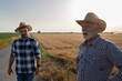 © Budimir Jevtic - Two male farmers standing on road next to harvested field.