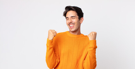 hispanic handsome man looking extremely happy and surprised, celebrating success, shouting and jumping