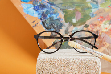 Wall Mural - eye glasses on concrete block and palette brown background, artist workshop concept