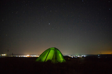 Wall Mural - night landscape tent against the background of the starry sky and city lights