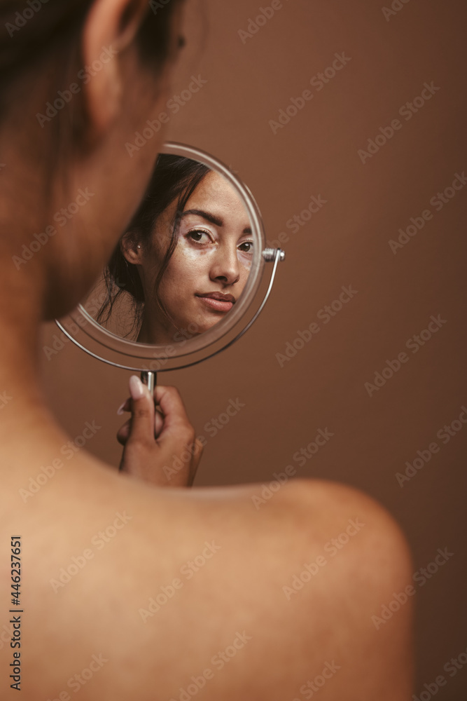 Woman looking in the mirror - obrazy, fototapety, plakaty 