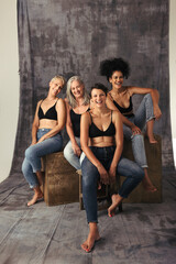 Wall Mural - Full length shot of diverse women laughing together in a studio