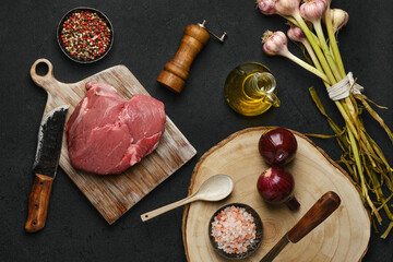 Wall Mural - Overhead view of raw beef ball tip steak with ingredients on black background