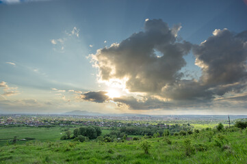Wall Mural - beautiful summer landscape, sun rays at sunset over the city of ivano-frankivsk