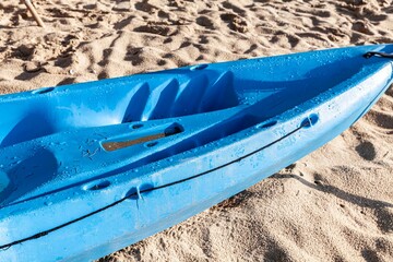 The blue kayak is placed on the sand at the beach. Prepared for the resort's customers