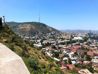 Wall Mural - Panoramic skyline city and landscape aerial view of Tbilisi, capital of Georgia, on hot summer day with landmarks, statues, buildings, river bank, bridges and many other tourist attraction churches