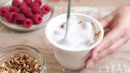 Wall Mural - Plain yogurt with granola and raspberries in plastic jar on wooden table. Eating healthy food, snack or diet meal