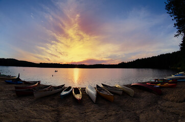 canoes on the shore of the lake in a sunset