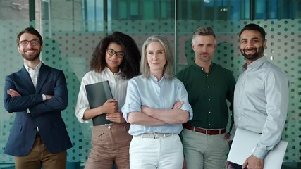 Wall Mural - Happy diverse business people office workers team standing in row looking at camera. Multiethnic professional employees executives group posing together for corporate portrait, leadership. Slow motion
