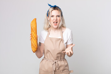 Wall Mural - young pretty albino woman looking angry, annoyed and frustrated with a bread baguette