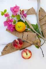 Sticker - Top view of pink bougainvillea flower with fig peaches, lemon and dry leaves on a white background