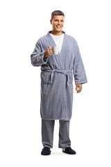 Wall Mural - Full length portrait of a young man in a bathrobe holding a cup