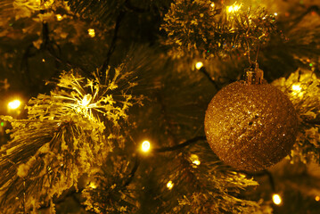 Canvas Print - Closeup shot of a Christmas tree decorated with shiny ornaments and lights