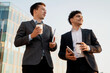 © muse studio - Businessmen young people working in business suits are holding coffee with them and gadgets in their hands. They are discussing a new startup project. Successful colleagues work together.