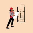 © Sophie Alp - architect holding floor plan at construction site. woman engineer with apartment layout in building zone