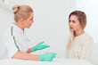 © shapovalphoto - Young woman beautician talking with a young blond woman about new facial skin care procedures, Professional cosmetician examining face skin