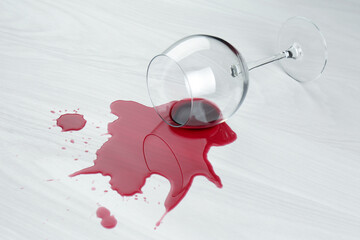 Canvas Print - Overturned glass and spilled wine on white wooden table