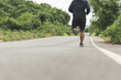 © Chanakon - Man wearing sportswear running on the road with mountain background. Young man jogging for exercise in the nature. healthy lifestyle and sports concept.