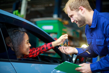 Wall Mural - A female customer get car key from mechanic engineer.