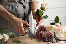 Florist Cutting Flower Stem With Pruner At Workplace, Closeup