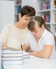 Sticker - Old teacher helps to girl with syndrome doing homework at library. Education for disabled children concept