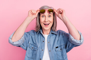 Poster - Photo of astonished aged lady hand eyewear wear blue shirt isolated on pastel pink color background