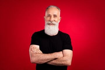 Portrait of attractive cheerful content strong grey-haired man instructor folded arms isolated over bright red color background